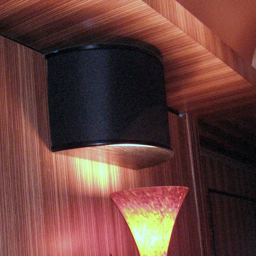 In-wall speaker and sconce set into zebrawood paneling in a dB Audio theater